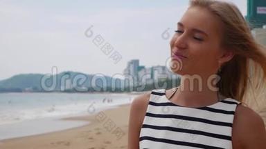 穿着黑白衣服的年轻女子独自走在热带海滩上，在暴风雨的背景下看着摄像机